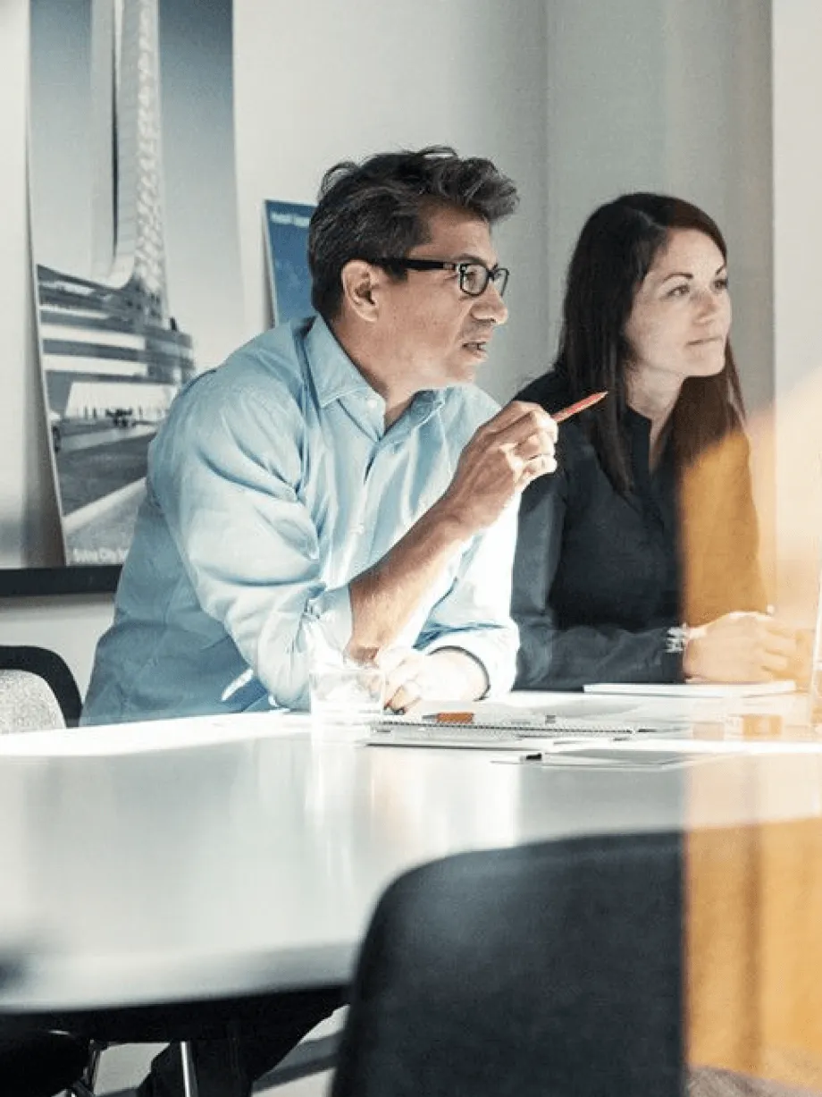 Two operations leads reviewing figures in a meeting room