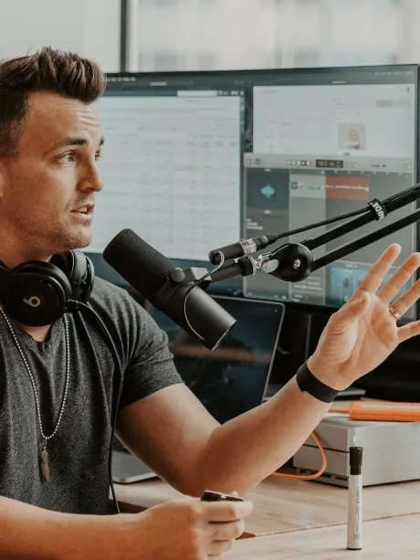 Content creator recording at a desk with two monitors